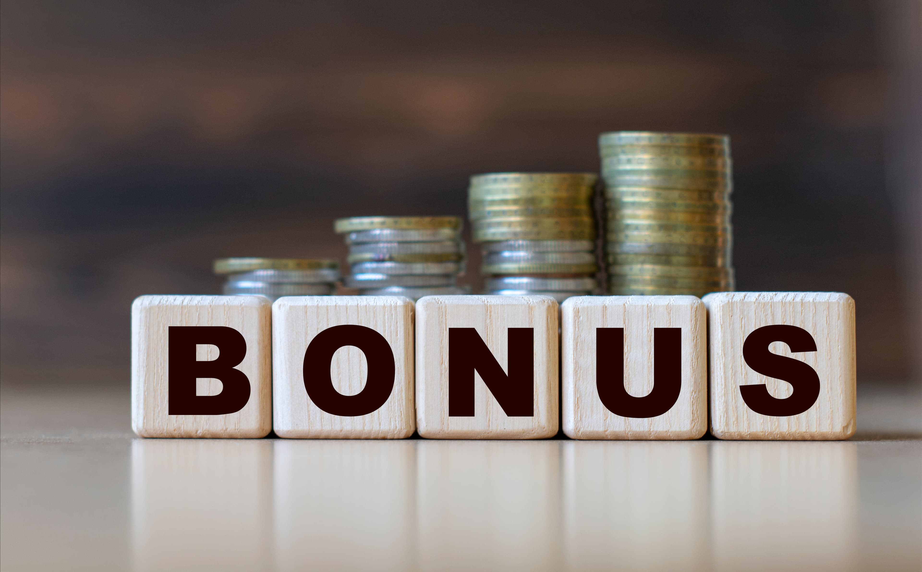 BONUS word on diced on a beautiful dark background with coins. Business concept