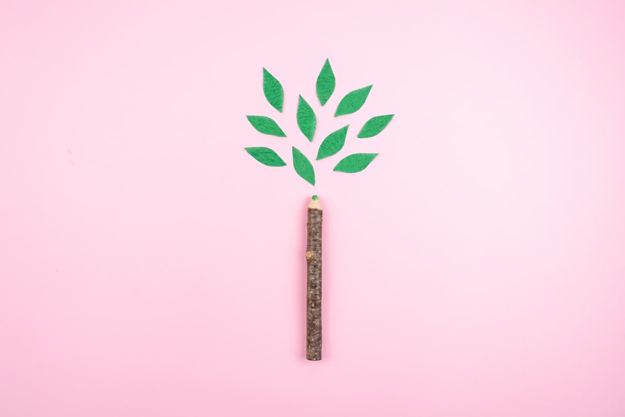 Ecological friendly, sustainable environment, Eco conscious concept with pen in the form of a tree trunk with green leaves on pink background.