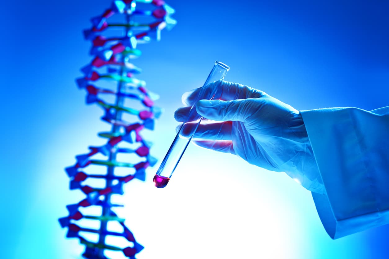 Close-up of a hand holding a chemistry test-tube with a chemical solution in a bio-chemistry DNA genetic research laboratory, GMO, human, animal, plants genetics research.