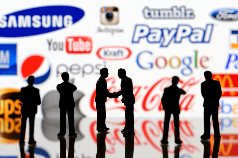 İstanbul, Turkey - April 5, 2014: Businessman figurines standing in front of Apple iPad monitor displaying well-known world brands logos, including Apple, Coca-Cola, Mc Donalds, Nike, ebay, Google, YouTube. ups.